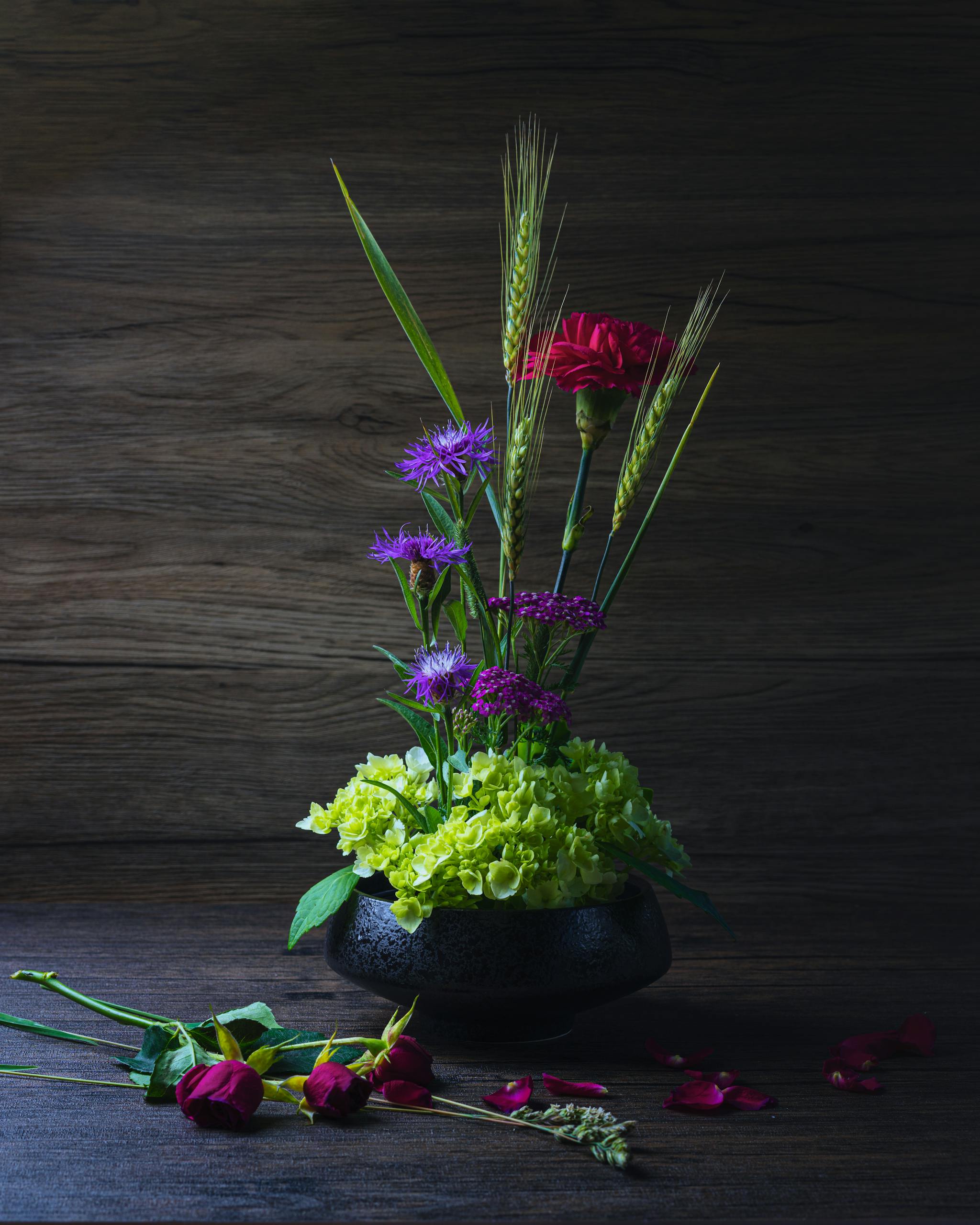 A striking floral arrangement in a vase with vivid hues on a wooden surface.