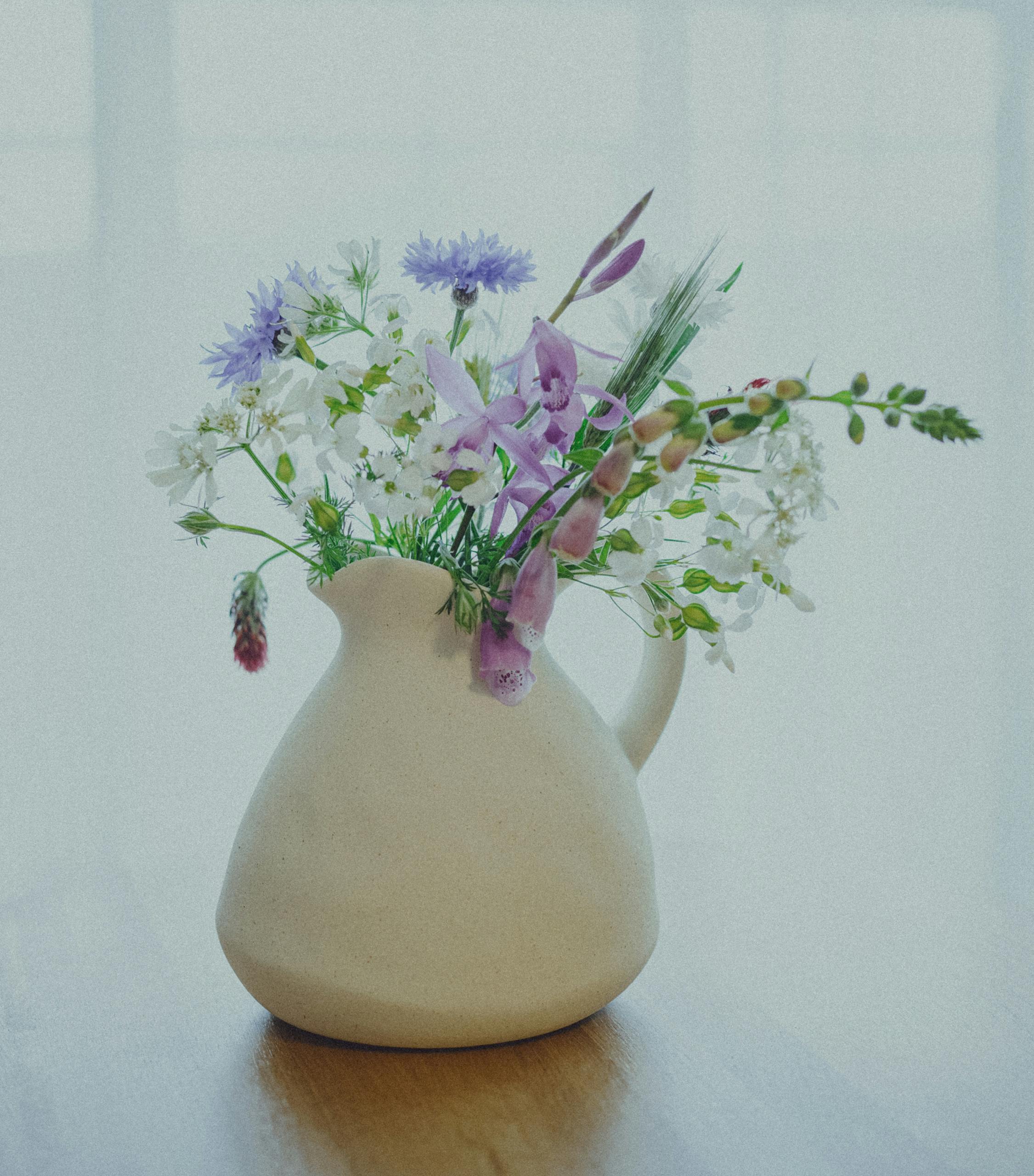 Delicate ikebana floral arrangement in a ceramic vase, showcasing Japanese artistry in a modern setting.